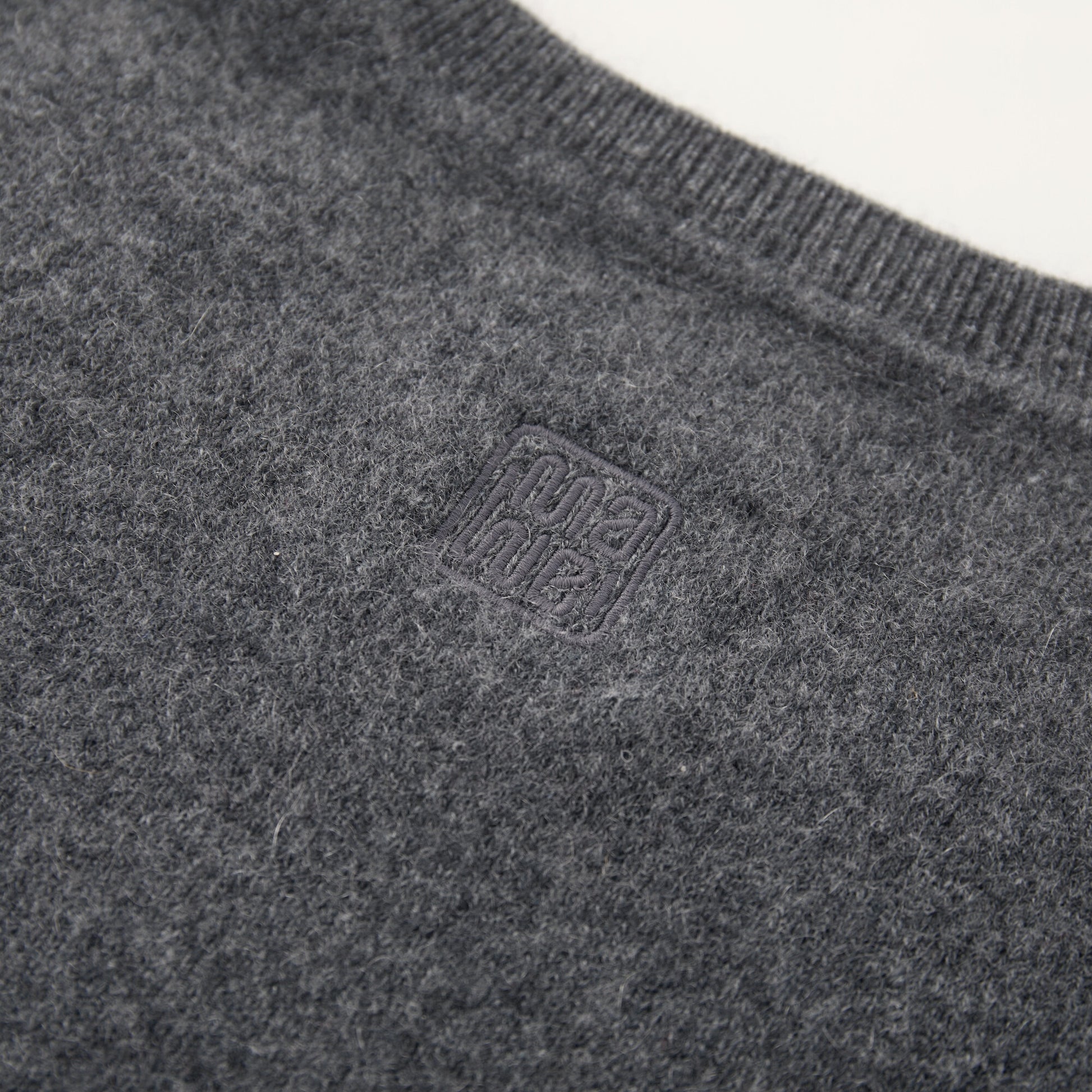 MA03 Cashmere Short Sleeve Crewneck Sweater by Mawei, grey, fabric and logo embroidery detail close-up, back view.