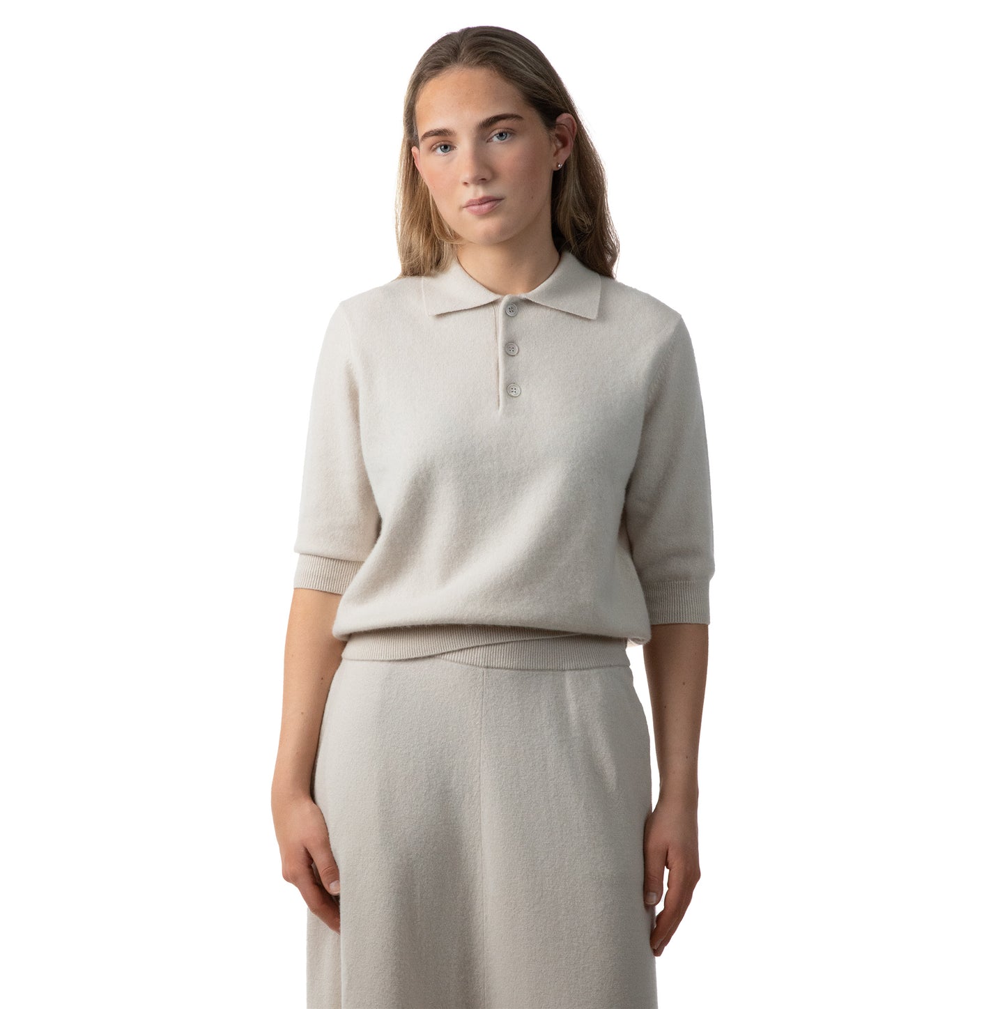 MA09 Cashmere Short Sleeve Polo Sweater, MA34 Cashmere A‑Line Skirt with pockets by Mawei, off white, female model, front view.