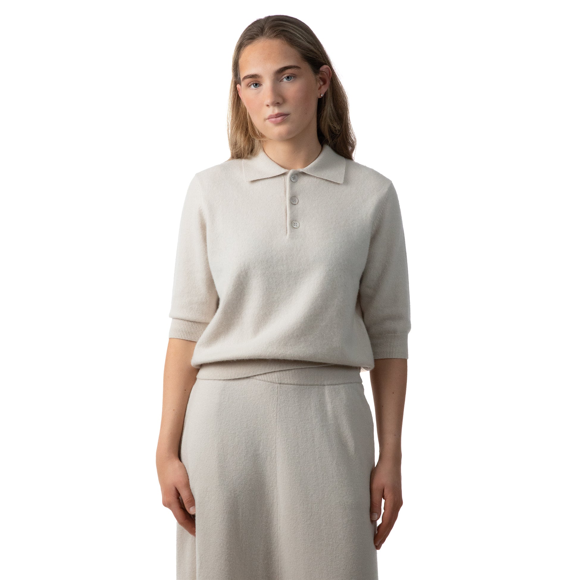 MA09 Cashmere Short Sleeve Polo Sweater, MA34 Cashmere A‑Line Skirt with pockets by Mawei, off white, female model, front view.