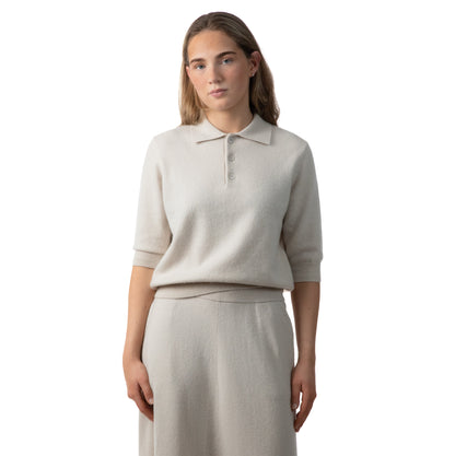 MA09 Cashmere Short Sleeve Polo Sweater, MA34 Cashmere A‑Line Skirt with pockets by Mawei, off white, female model, front view.