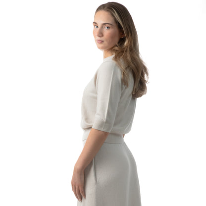 MA03 Cashmere Short Sleeve Crewneck Sweater and MA34 Cashmere A‑Line Skirt by Mawei, off-white, side view, female model.