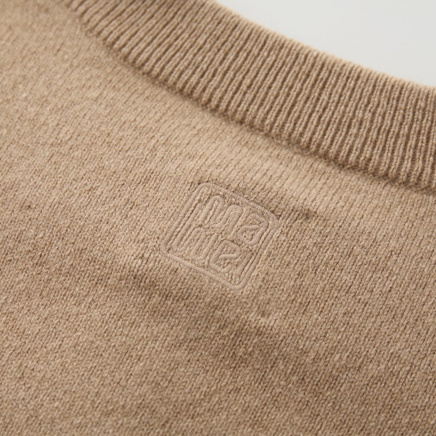 MA06 Cashmere Cardigan by Mawei, beige camel, fabric and logo embroidery close-up, back view.