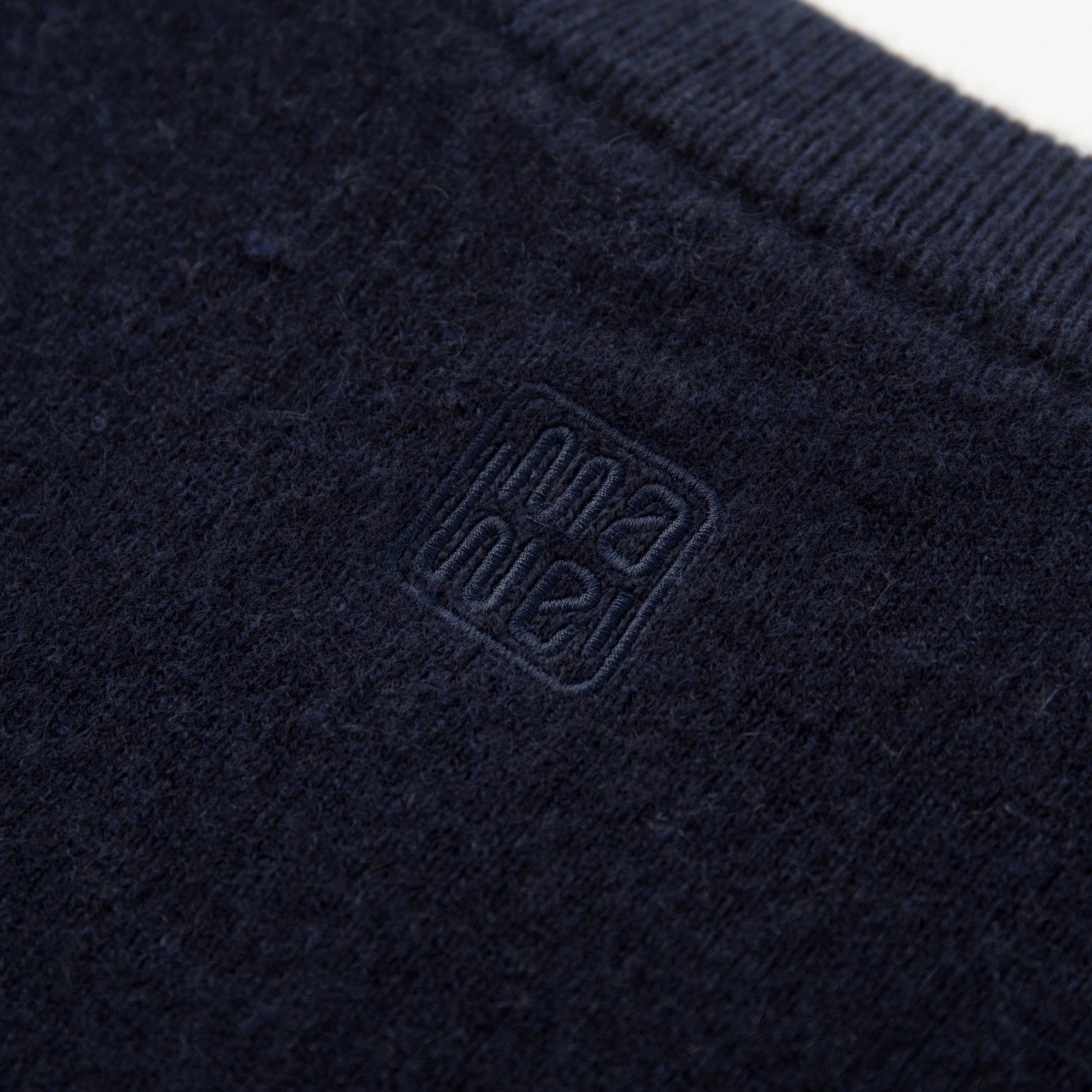 MA06 Cashmere Cardigan by Mawei, navy blue, fabric and logo embroidery close-up, back view.