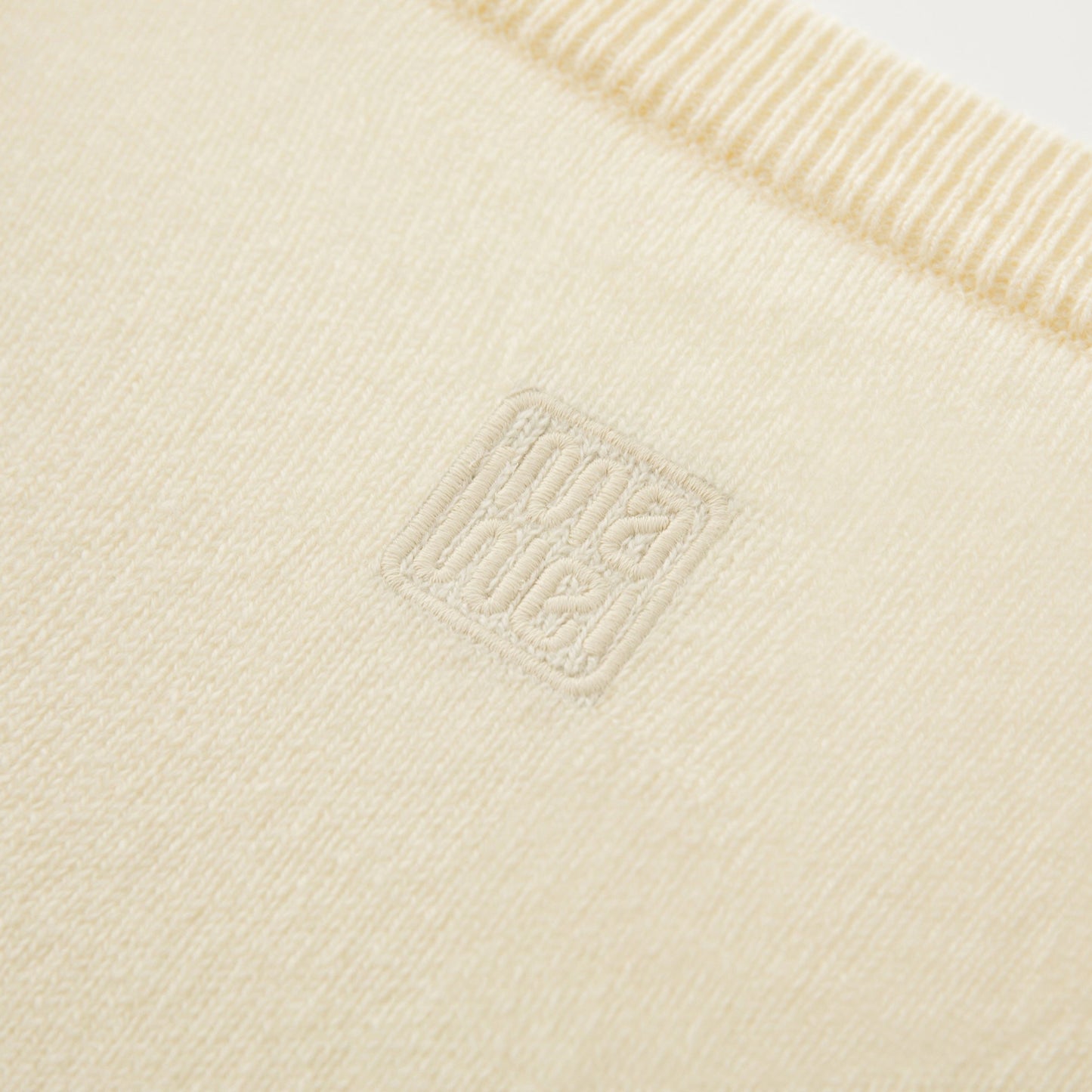MA08 Oversized Cashmere  V-neck  Sweater by Mawei, yellow, fabric and logo embroidery close up, back view.