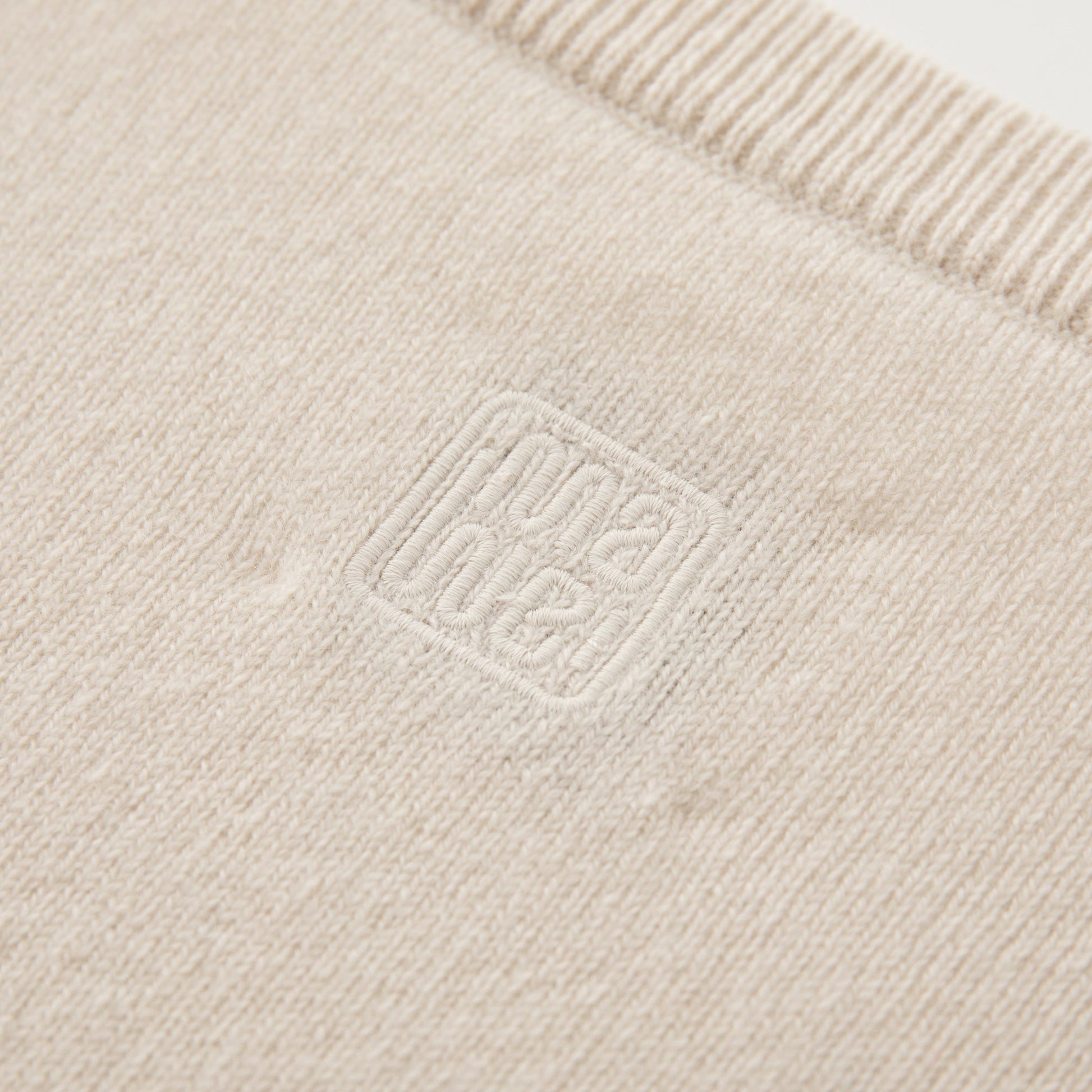 MA08 Oversized Cashmere  V-neck  Sweater by Mawei, off white, fabric and logo embroidery close up, back view.