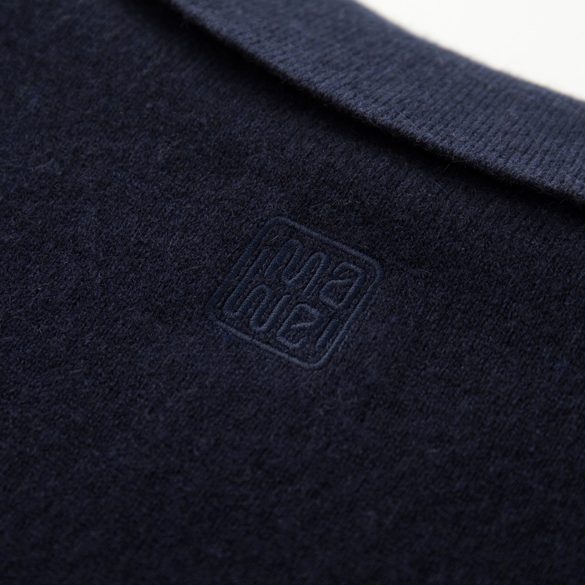MA09 Cashmere Short Sleeve Polo Sweater by Mawei, navy blue, fabric and logo embroidery close up, back view.